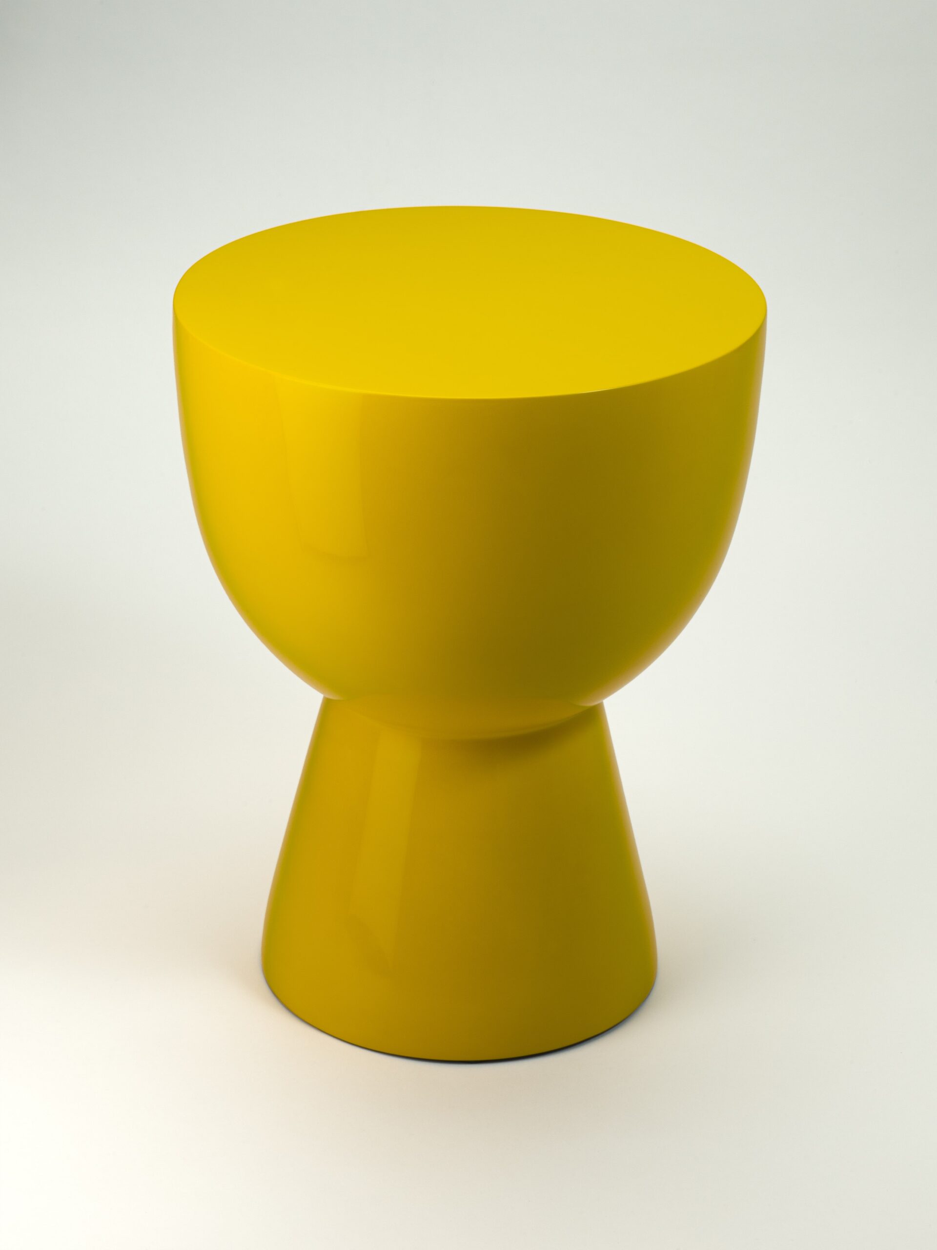 Productfoto van een felgele, moderne en abstracte kruk van Polspotten, een meubelwinkel in Amsterdam. De kruk heeft een glanzende afwerking en een symmetrisch ontwerp met een brede, ronde bovenkant en een taps toelopende basis. De productfotografie is verzorgd door Jasper Mulder en vastgelegd tegen een neutrale witte achtergrond voor een strakke en minimalistische uitstraling.
