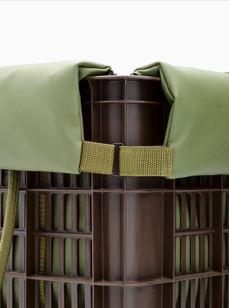Detailfoto van een opvouwbare opbergkrat met gewatteerde olijfgroene voering, verstelbare band en kunststof constructie.